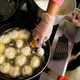 Aerial view of a cook frying latkes in a restaurant kitchen